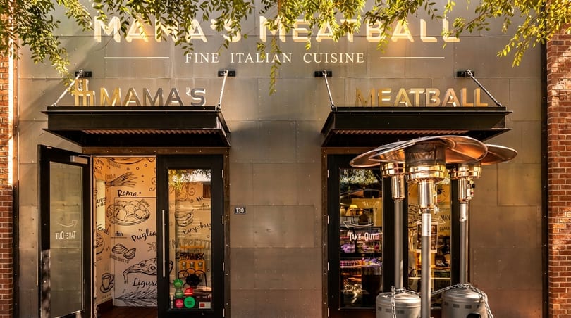 Mama's Meatball restaurant exterior with two doors, a "Take Out" sign, and outdoor heaters.